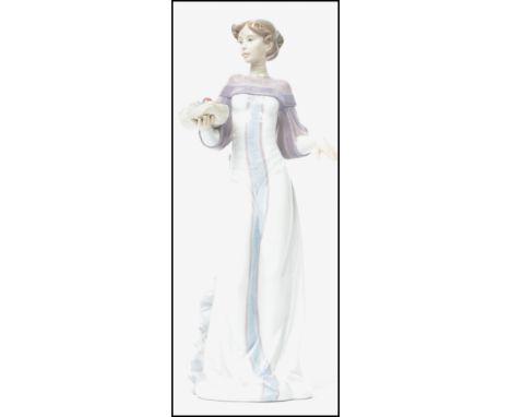 A Lladro ceramic figurine entitled ' Winter Love  ' depicting a lady in dress holding a platter of food. Impressed 6621 to ba