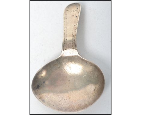 A Georgian silver caddy spoon of stub form bearing monogram with handle. The marks verso being illegible. Total weight 6.7g /