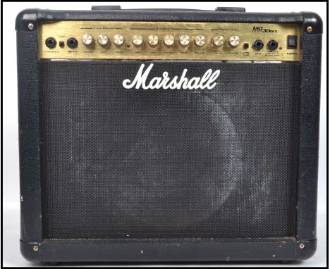 A vintage Marshall music amp - amplifier MG Series 30DFX in black case with handle atop over dials and speaker. Measures 42 c