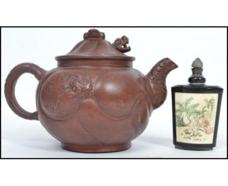 An Oriental Yi Xing terracotta teapot having a metamorphic dragon to body with moving head and tongue being stamped to the ha