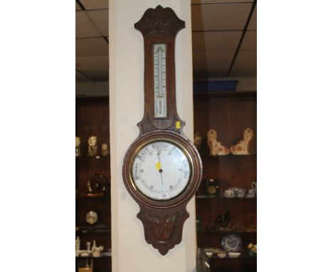 A CARVED OAK BAROMETER 