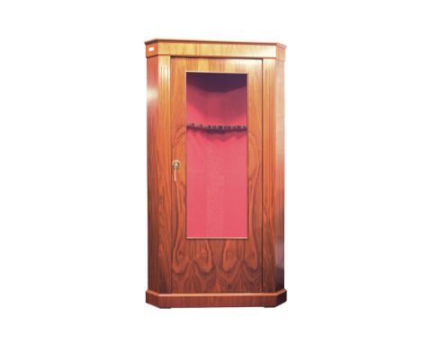 A GLASS FRONTED CORNER GUN CABINET, an eight gun safe with a walnut finish, the interior lined with red baize, bullet proof g