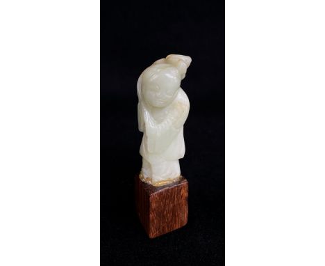 CHINESE CELADON JADE CARVING OF A BOY, holding a flowering lotus branch, hadwood base, overall 10cms hCondition report: Comme