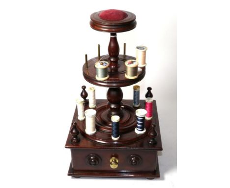 A composite mahogany two tier bobbin stand with pin cushion mount, single drawer to the front on four bun feet.      In good 