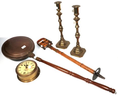 A brass bulk head clock (with key), a pair of brass candlesticks, a shooting stick and a copper bed warmer (4)