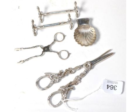A pair of silver grape scissors, DJS, London 1967, the handles cast with foxes; a pair of silver knife rests, Chester 1904; a