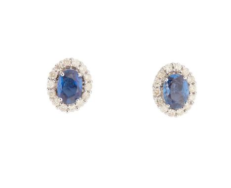 A pair of sapphire and diamond cluster earrings each claw-set with an oval-cut sapphire in a border of round brilliant-cut di