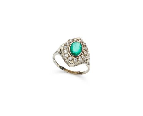 A 1920s emerald and diamond cluster ring collet-set with an oval-cut emerald in a border of old-cut diamonds, pierced scrolli