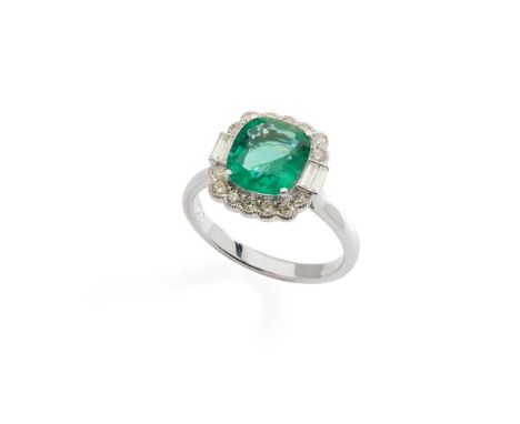 An emerald and diamond cluster ring claw-set with a cushion-cut emerald in a border of round brilliant and baguette-cut diamo