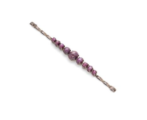 A star-ruby bracelet  claw-set with nine graduated cabochon star rubies, to ribbed links and a concealed clasp, unmarkedDimen