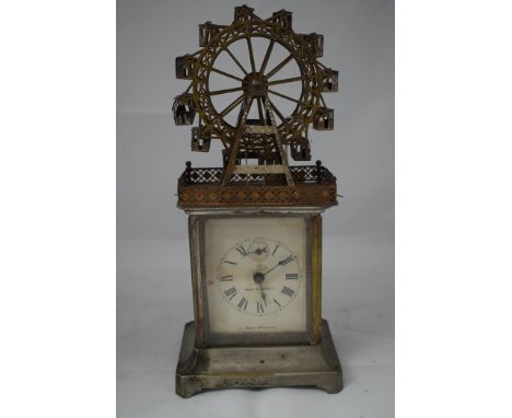 An H.A.U. (Hamburg Amerikanische Uhrenfabrik) tinplate automaton carriage clock, mounted with a ferris wheel above white enam
