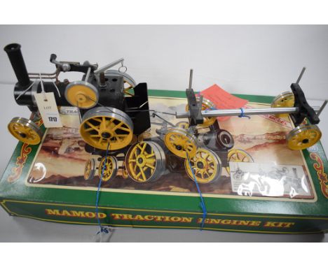 A Mamod Traction Engine Kit, with yellow wheels, the tractor hauling lumber trailer, boxed.