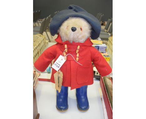 A Paddington bear toy, in red jacket with blue Dunlop wellingtons.