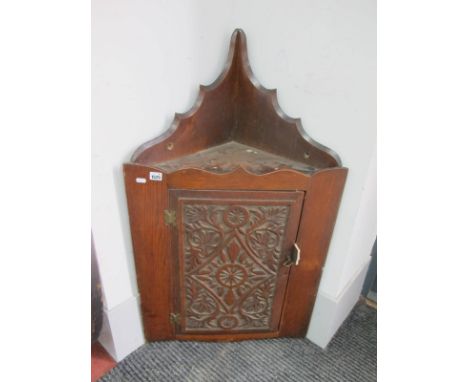 An Early XX Century Corner Cupboard, with a shaped back, carved panelled door, internal shelf.