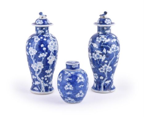 A pair of Chinese blue and white vases and covers, late 19th century, painted with flowering prunus on a crackled-ice ground,