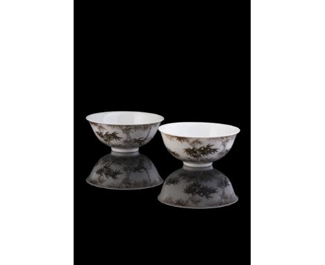 A pair of Chinese bowls, Republican, painted to exteriors with bamboo in tones of black enamels, apocryphal Qianlong blue sea