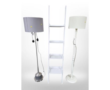 A contemporary four tier shelf and two standard lamps 