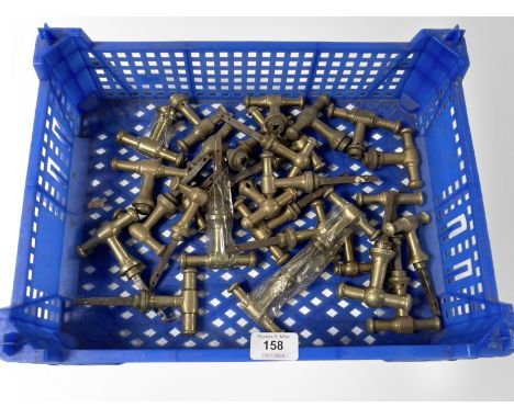 A crate of vintage brass 'T' shape door handles