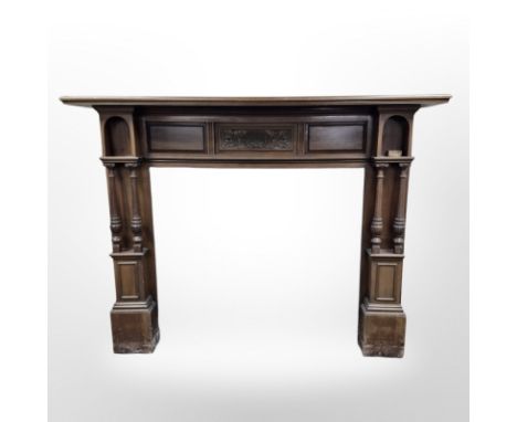An Art Nouveau carved walnut fire surround, 183 cm wide (interior measurement 115 cm x 100 cm ) 