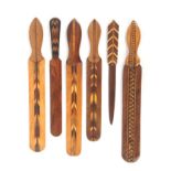 Six Tunbridge type paper knives, decorated with chequer and feather coloured inlays, largest 29.