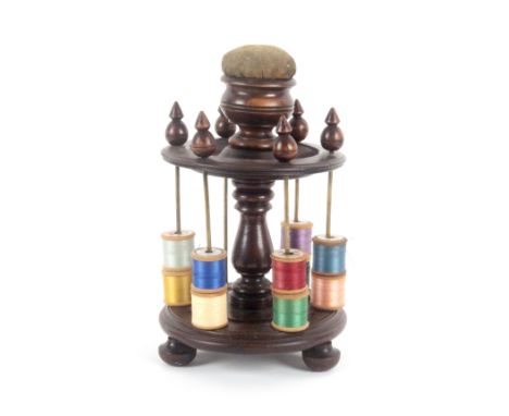 A large mahogany reel stand, the turned circular base on three turned feet to a central baluster supporting a circular tier c