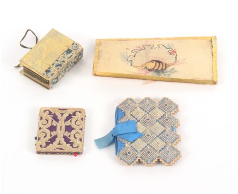 Four card sewing accessories, comprising a stitched, stacked and pierced card needle book, blue ribbon tie and complete with 