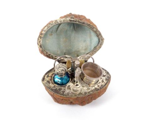A good example of a miniature walnut sewing etui for a child or doll, contained in a hinged natural walnut, the interior lid 