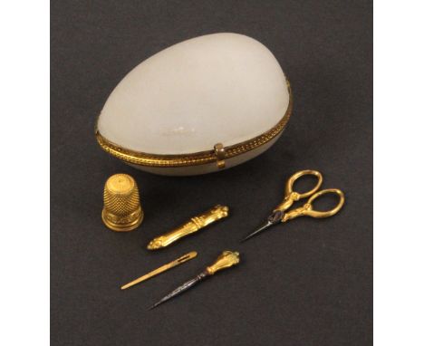 A French etui for a child or doll, circa 1880, the frosted glass and gilt mounted egg form case internally fitted with a tool