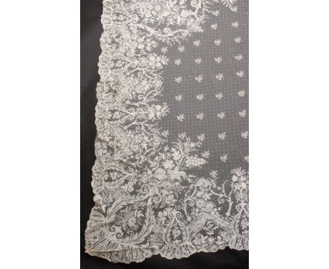 An attractive late 19th Century/early 20th Century Brussels bobbin applique lace shawl, with a broad floral and leaf scroll b