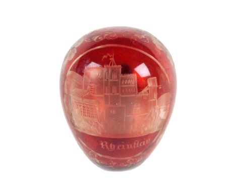 A good 19th Century ruby glass overlay etched glass darning egg, with an oval cut panel of a castle titled 'Rhein Heiu' withi