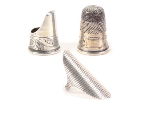 Three 19th Century silver thimbles, comprising a Dutch thimble ring with ribbed face, a steel topped thimble with engraved fr