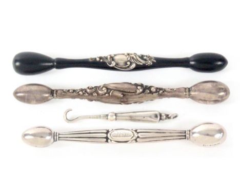 Three glover darners and a button hook, comprising two white metal examples with decorated handles both stamped 'Sterling', 1