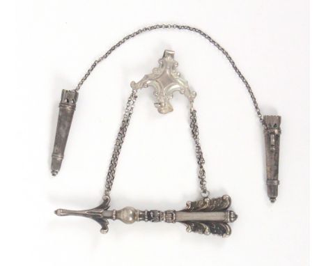 Two German silver knitting needle retainers, comprising an elaborate example in the form of an arrow on chains to a leaf scro