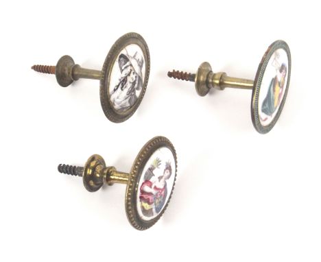 Three late 18th Century English enamel mounted gilt brass handles or curtain tie backs, each with oval enamel plaque, one wai