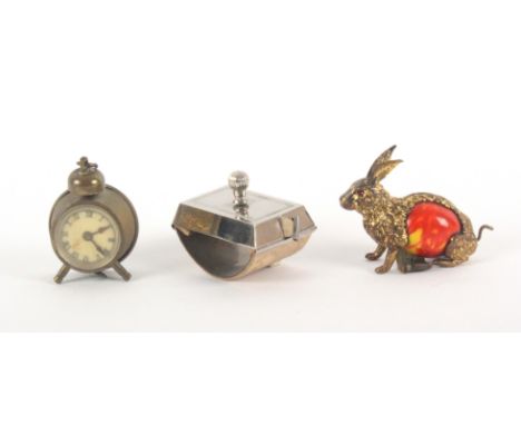 Three metal novelty tape measures, comprising a seated hare with celluloid body, the complete printed tape in ins. and cms, a