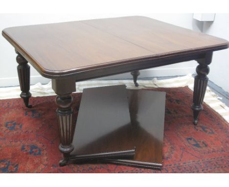 VICTORIAN MAHOGANY WIND OUT EXTENDING DINING TABLE, the moulded edged top with curved angles, two additional leaves, on balus