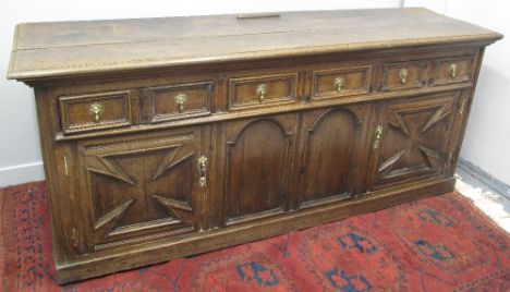LATE 17TH CENTURY OAK DRESSER BASE, having planked, moulded edged top over three moulded frame frieze drawers, above two unus