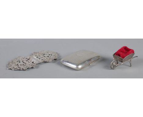 A white metal nurses belt buckle, together with a novelty silver wheelbarrow pin cushion and silver cigarette case monogramme