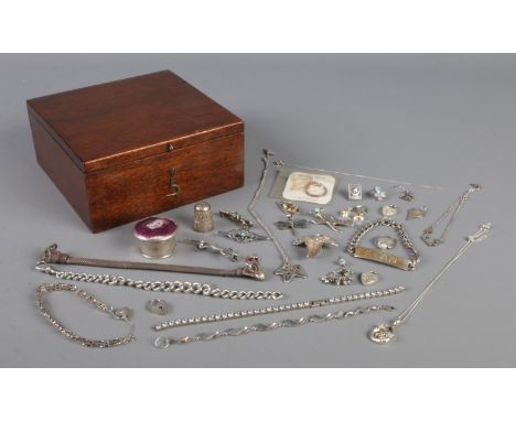 A mahogany box containing an assortment of silver jewellery, to include brooches, identity bracelet, pendants and earrings et