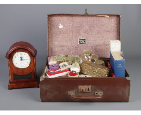 A faux leather suitcase containing an assortment of collectable items. To include a set of six white metal napkin rings, mode