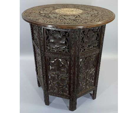 CARVED EASTERN HARDWOOD FOLDING TABLE - having profusely carved leaf and berry detail, the top with bone inlays to the centre