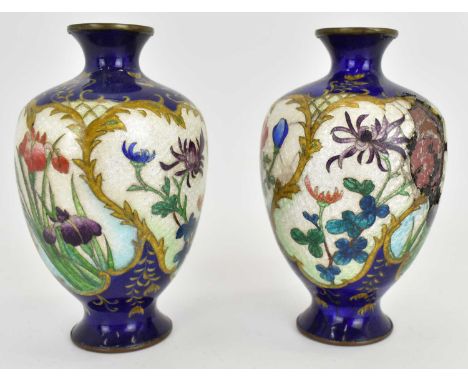 A pair of early 20th century cloisonné vases of bulbous shape, with floral panels on cobalt blue ground, height 12cm (2).Cond