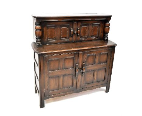 ERCOL; a dark stained elm court cupboard, comprising two pairs of fielded and panelled cupboard doors, 127 x 122 x 46cm.