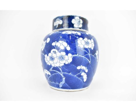 A late 19th/early 20th century porcelain lidded ginger jar, decorated with hand-painted cherry blossom on a blue ground, with