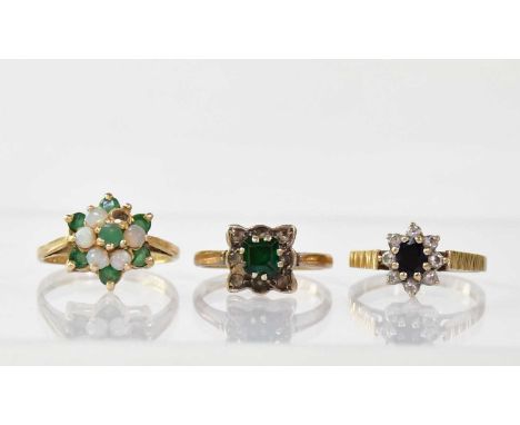 Three 9ct gold rings comprising an opal and emerald floral cluster (af), size L, a ring with claw set small square emerald, w