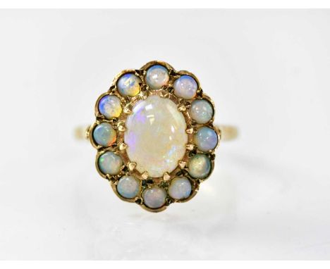 A 9ct gold floral cluster ring, the central opal cabochon within a border of twelve smaller opals, size L, approx. 3.2g.