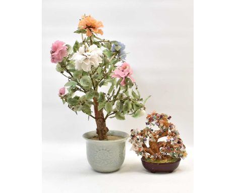 An Oriental carved hardstone and wood-effect plant with flowering buds and green leaves, in a celadon-style planter, height 5