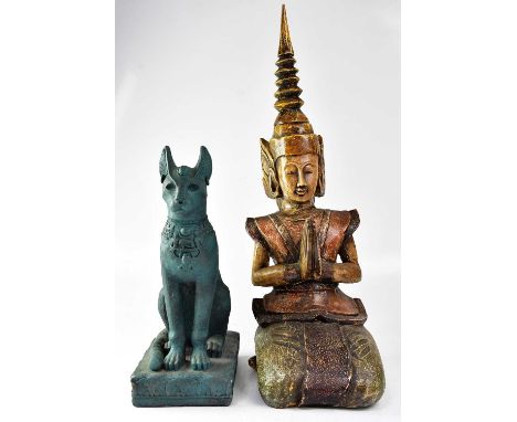 A cast Egyptian-style model of a cat, height 42cm, and a wooden carved Thai praying deity, height 67cm (2).Condition Report: 