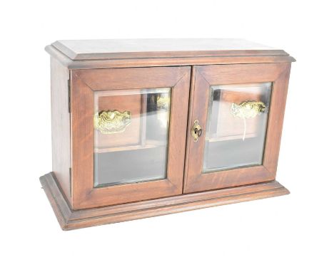 An early 20th century mahogany smoker's cabinet, with two shallow silver-plated pin dishes and central recess with three pipe