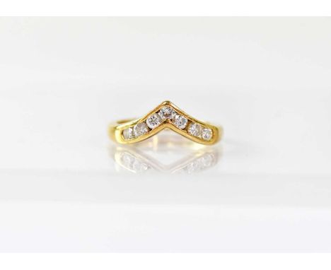 An 18ct gold wishbone ring channel set with seven small brilliant cut diamonds, size K, approx. 3.5g.